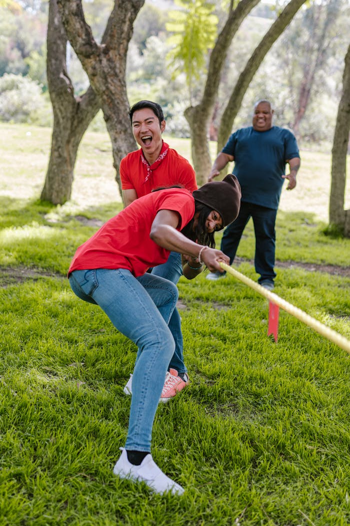 gallery-01 A lively tug of war game in a sunny park showcasing teamwork and unity.